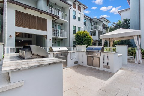 a backyard with an outdoor grill and barbecue area with apartments in the background