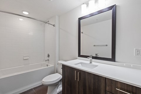 a bathroom with a sink toilet and shower and a mirror