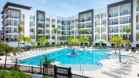 A large swimming pool in front of apartment buildings.