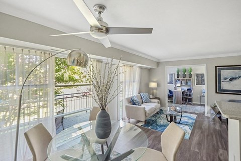 A modern living room with a glass dining table and chairs.