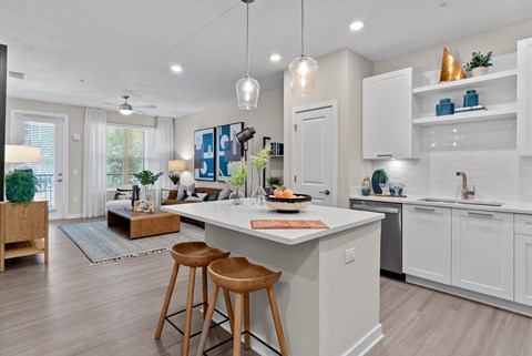 A modern kitchen with white cabinets and a central island.