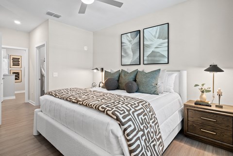 A bedroom with a large bed and a ceiling fan.