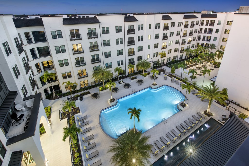 an overhead view of an apartment building with a swimming pool
