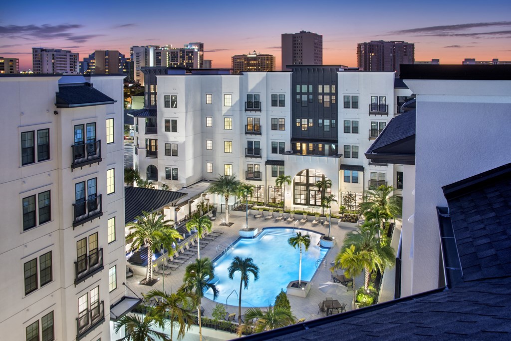 an aerial view of a swimming pool in front of an apartment building