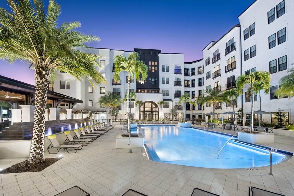 a swimming pool at a hotel with palm trees