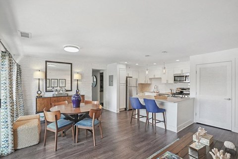 a spacious living room with a dining area and kitchen in the background