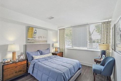 a bedroom with a bed and two windows