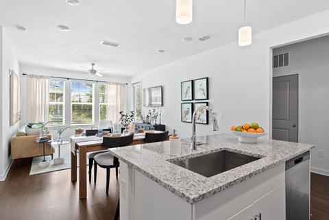 A kitchen with a granite countertop and a dining table with chairs.