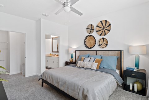 A bedroom with a large bed and a ceiling fan.