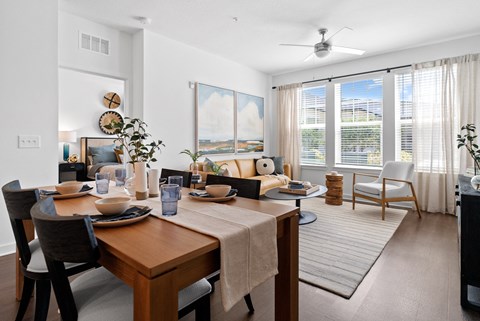 a living room and dining room with a table and chairs