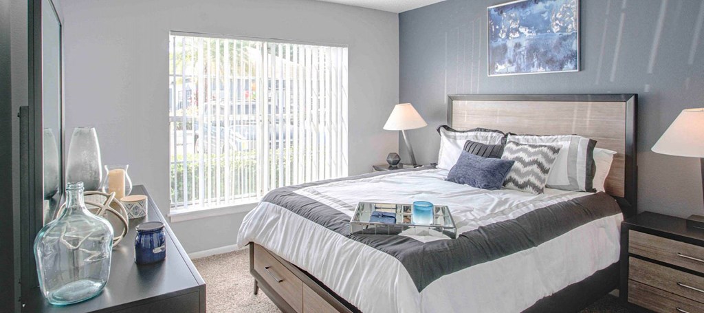 a bedroom with a bed and a large window