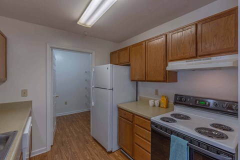 a kitchen with wooden cabinets and a white refrigerator and stove