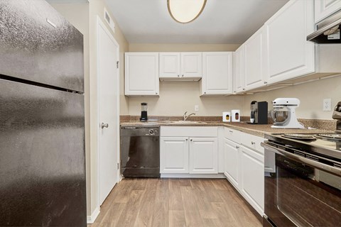 a kitchen with white cabinets and a stainless steel refrigerator
