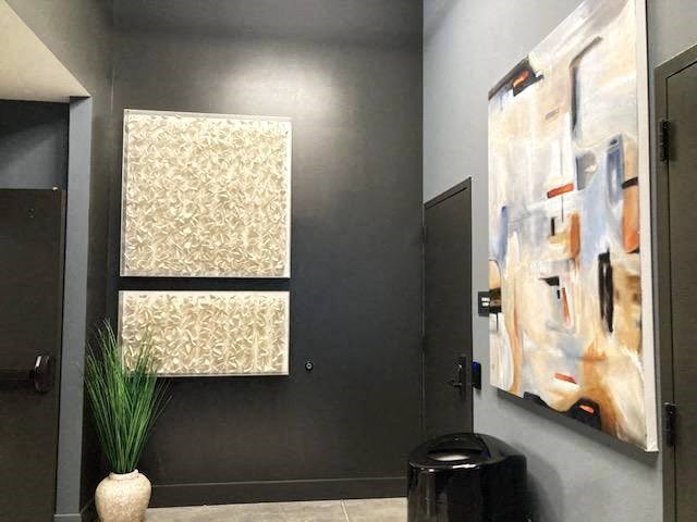 a bathroom with two paintings on the wall