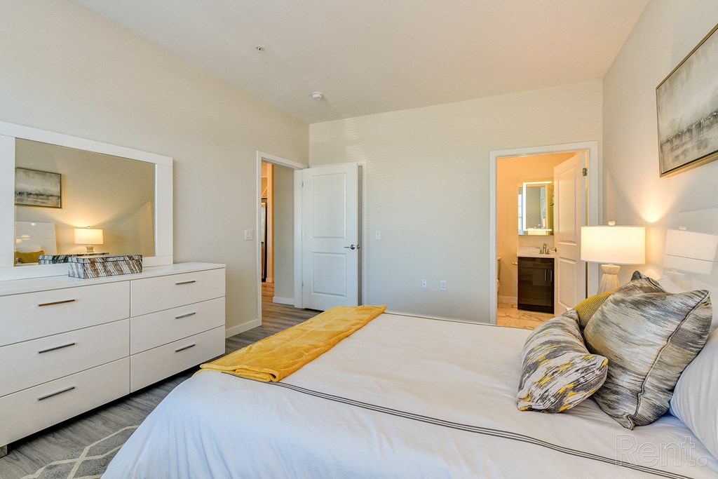 a bedroom with a large white bed and a bathroom at Solo at North Bergen, North Bergen, New Jersey