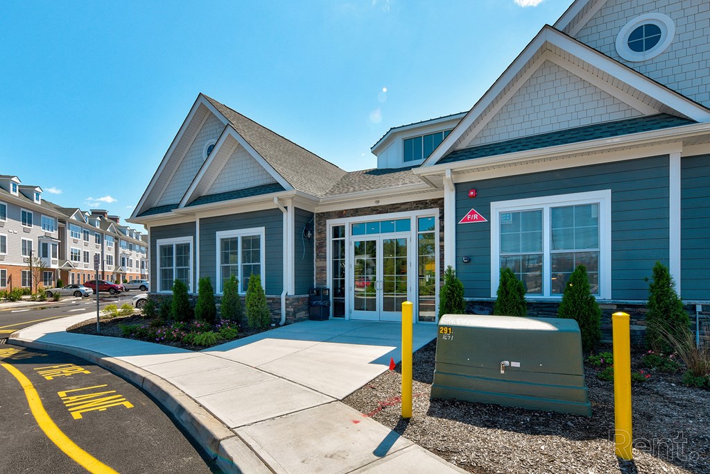 a blue building with yellow poles and a sidewalk in front of it  at Solo at North Bergen, North Bergen, 07047