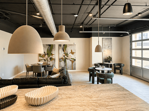 A modern living room with a large rug and a black couch.