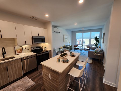 A kitchen with a white counter top and wooden cabinets.