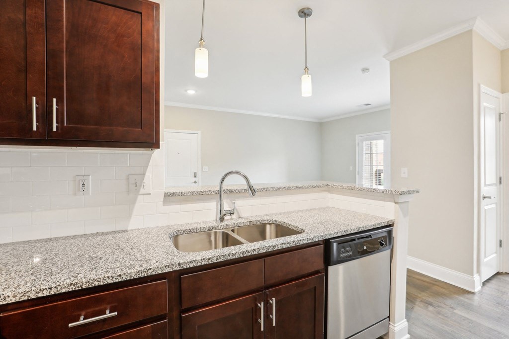 a kitchen with granite counter tops and a stainless steel sink