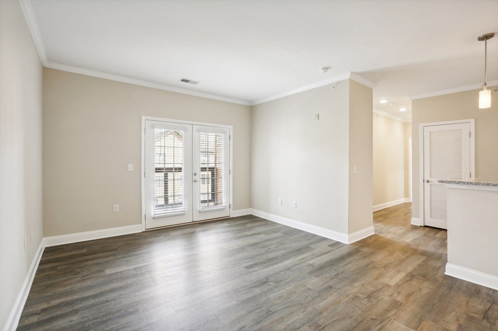 the living room and dining room in a new home with white walls and wood floors