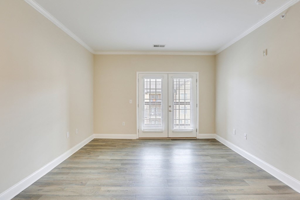an empty living room with white walls and doors