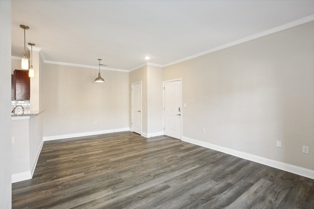 an empty living room with wood floors and white walls