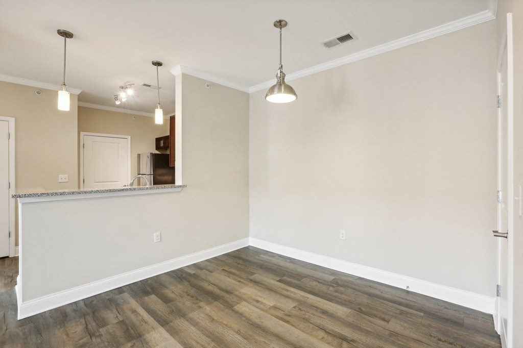an empty living room with wood flooring and white walls