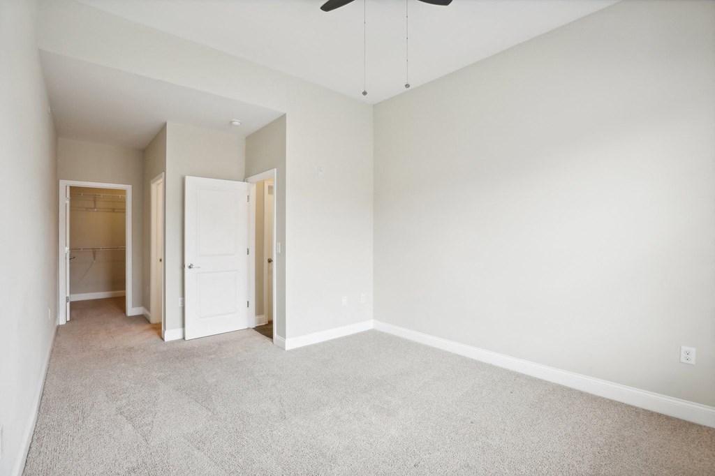an empty room with white walls and a ceiling fan
