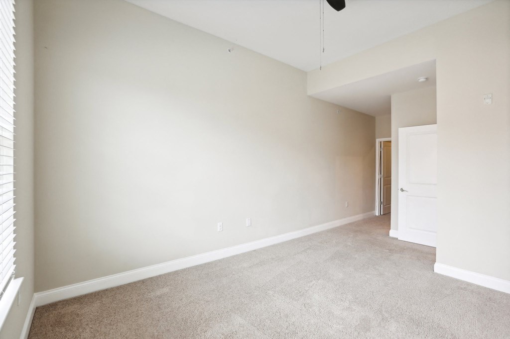 an empty living room with white walls and carpet