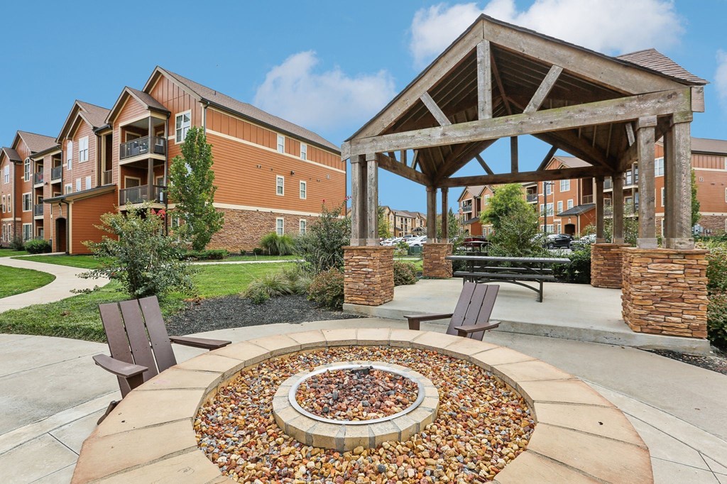 a fire pit with two chairs in front of a building