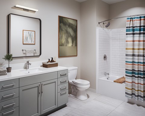 A bathroom with a white toilet, a sink with a mirror above it, and a shower with a colorful shower curtain.
