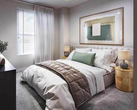 A bedroom with a large bed and a painting on the wall.