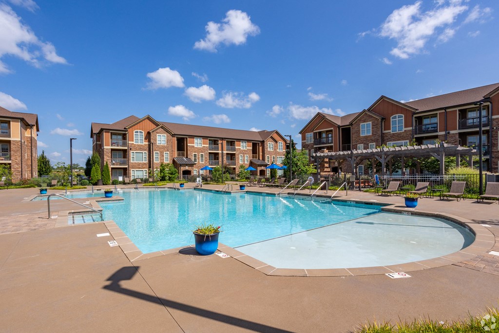 a swimming pool with an apartment building in the background
