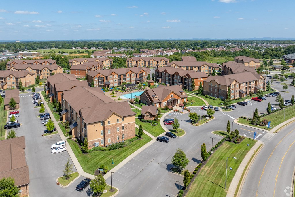an aerial view of an apartment complex with cars parked in a parking lot