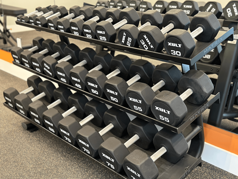 Luxury gym at The Rail at Bound Brook with strength training equipment and stylish design, offering fitness perks to residents in a pet-friendly Bound Brook apartment community.
