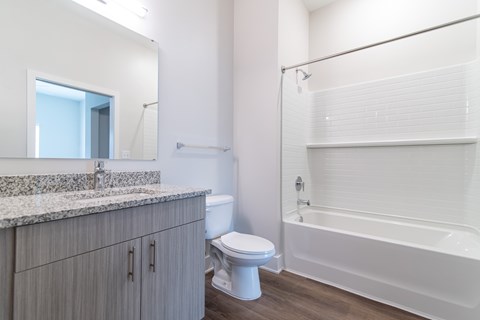 A white bathroom with a sink, toilet, and bathtub.