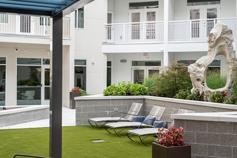 A white building with a balcony and a sculpture of a bone.
