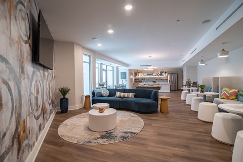 A modern living room with a blue sofa and a patterned wallpaper.