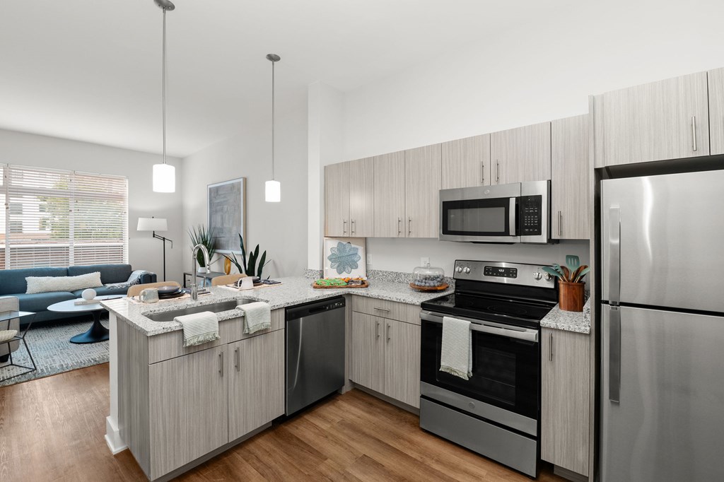 Modern kitchen with wooden cabinets at Novi at Concord apartments for rent in Concord, NC.