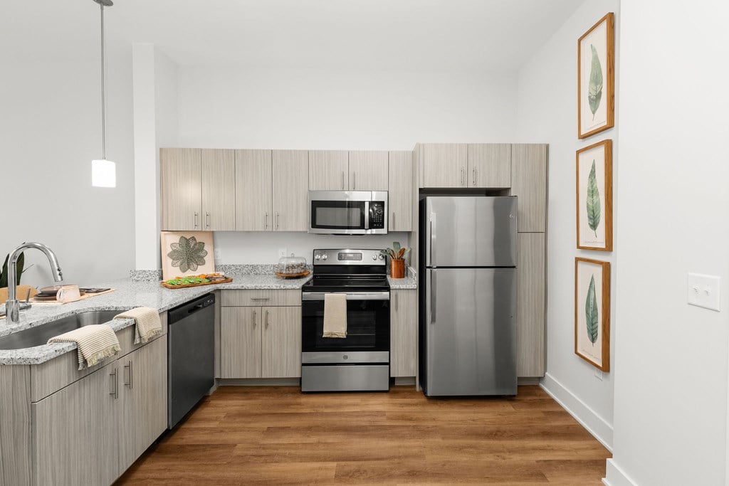 A modern kitchen with a refrigerator, oven, and sink.