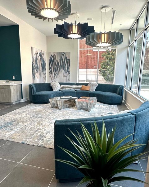 A living room with a blue couch and a rug.