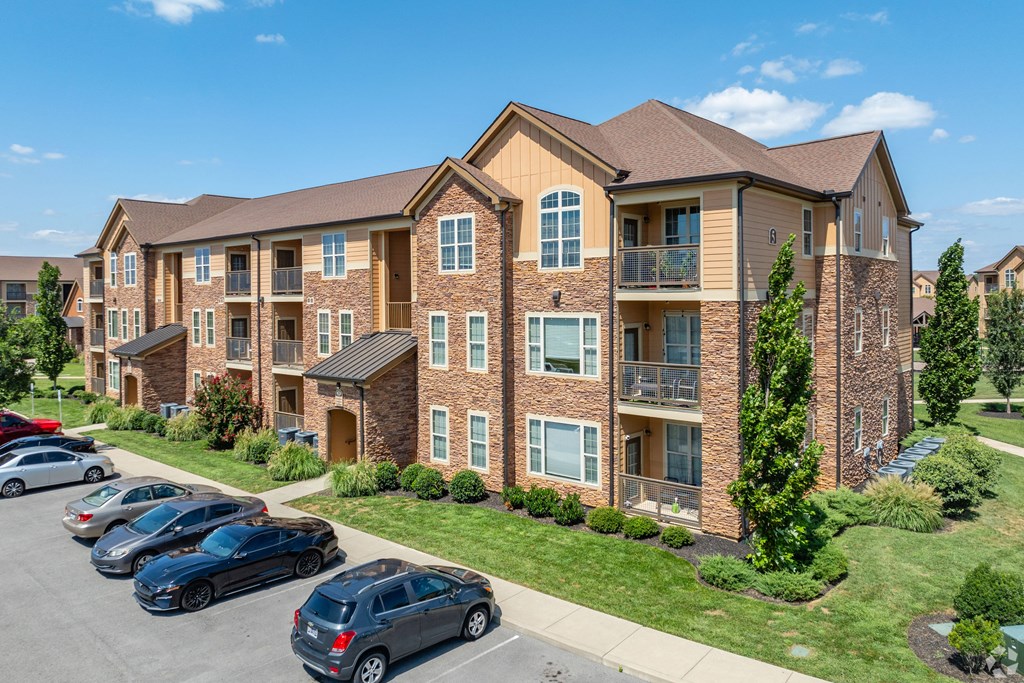an apartment building with cars parked in front of it