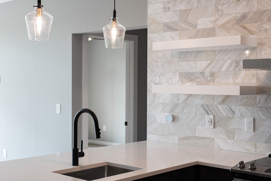 a kitchen counter with a sink and a door to a bathroom