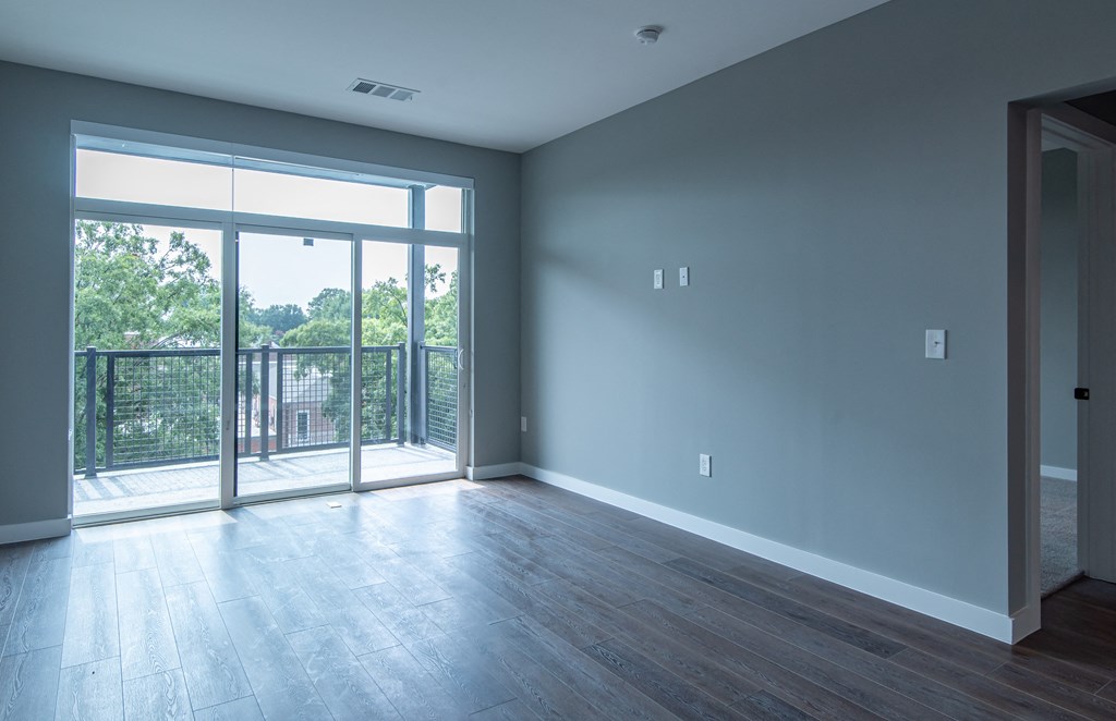 an empty living room with sliding glass doors to a balcony