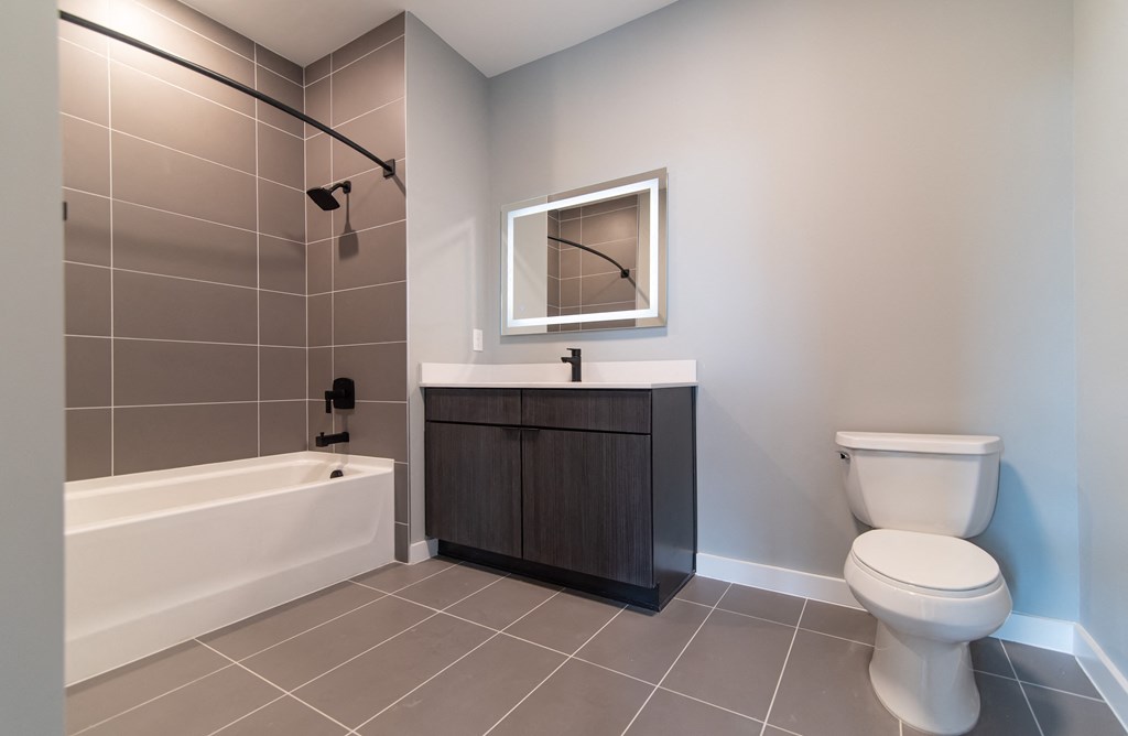 a bathroom with a toilet and a tub and a sink