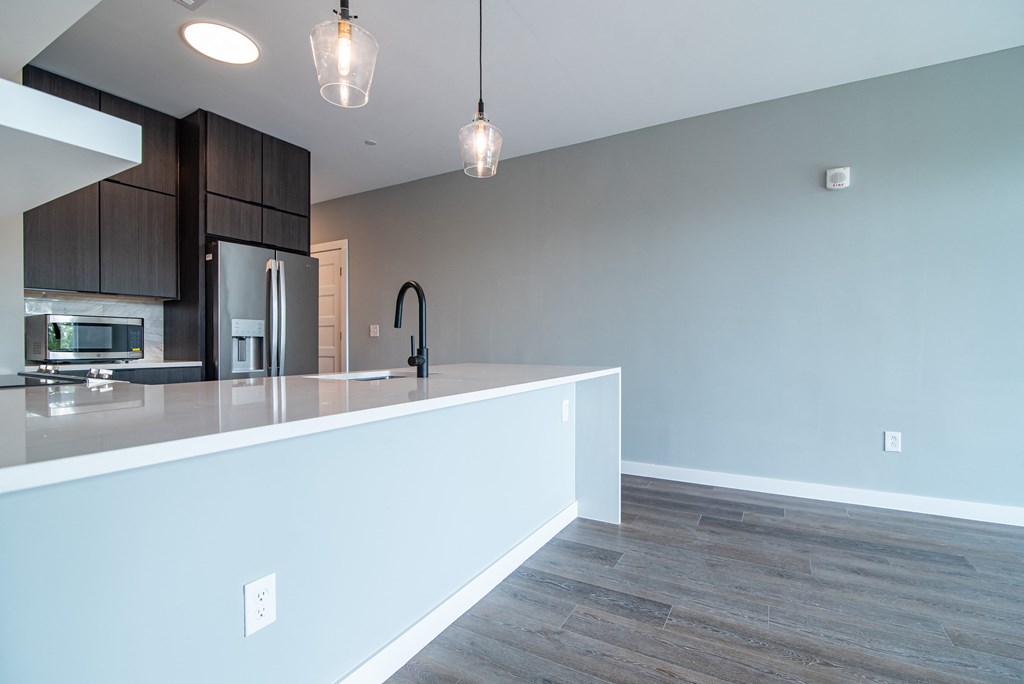 a kitchen with a large white counter top in a new home