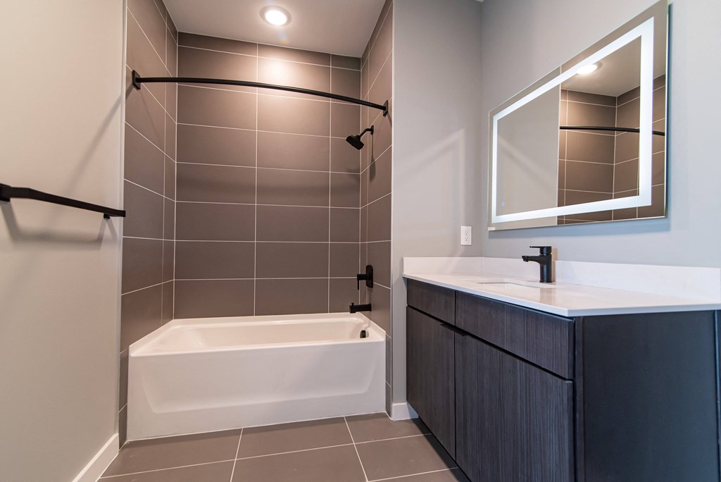 a bathroom with a tub and a sink and a mirror