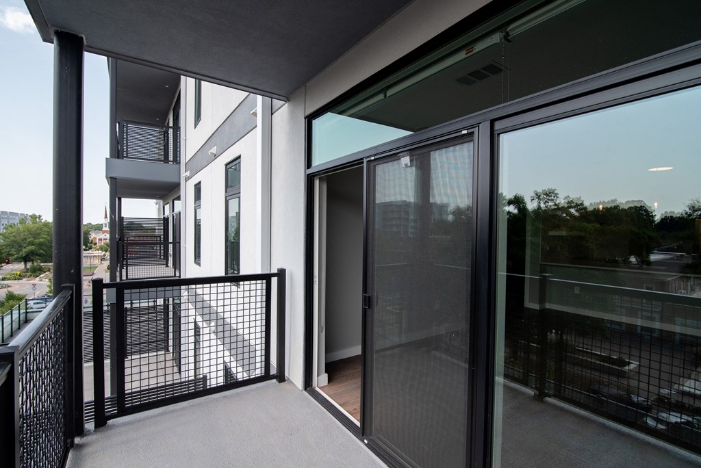 a balcony with glass doors and a view of the city