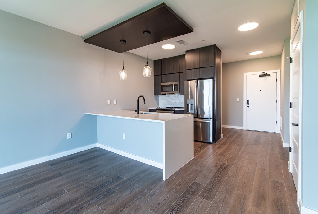 a kitchen with a white island and a stainless steel refrigerator