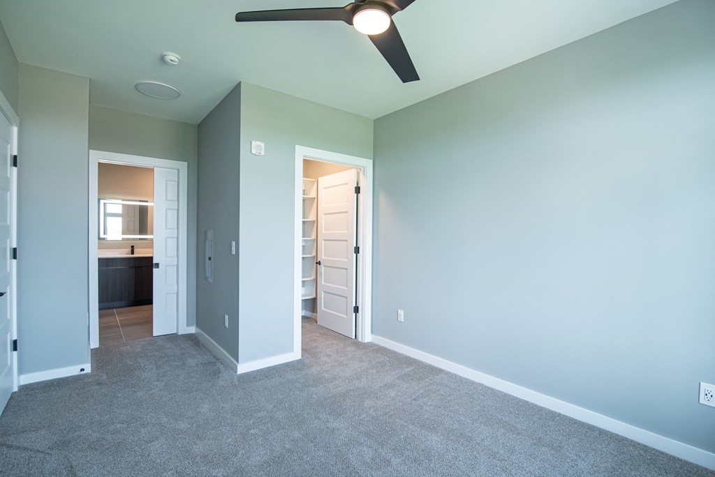 an empty room with a ceiling fan and a closet